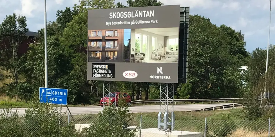 Byggskylt med information som är placerad invid en väg